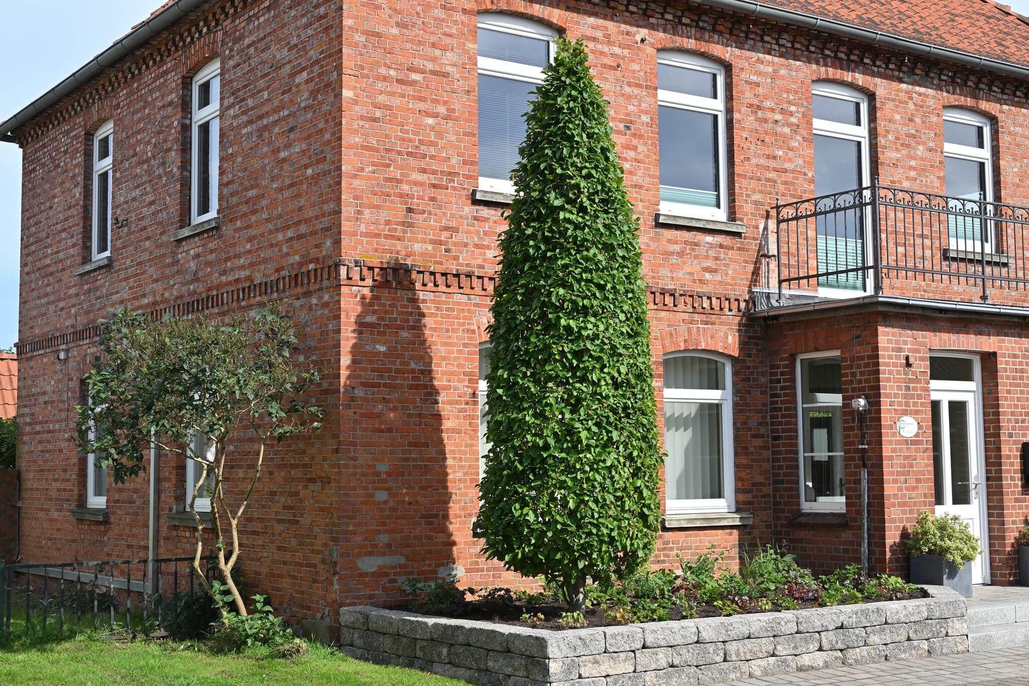 Backsteinfassade der Kanzlei Neuhaus mit Säulenbaum