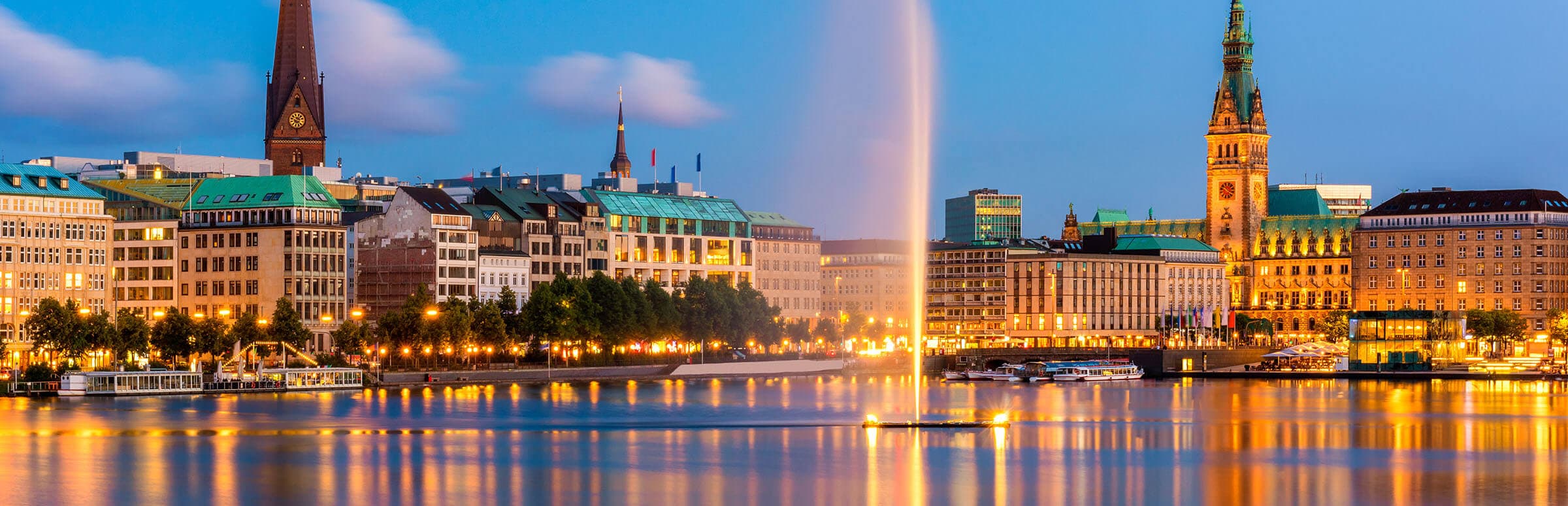 Hamburger Binnenalster mit Alsterfontäne und Rathaus in der Abenddämmerung
